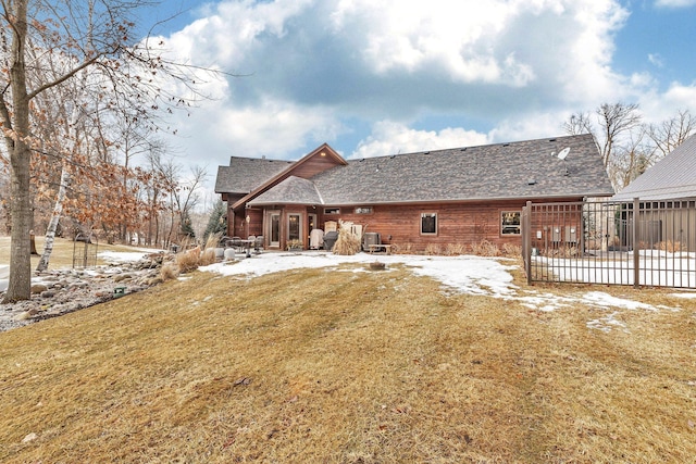 snow covered house featuring a lawn and a patio area