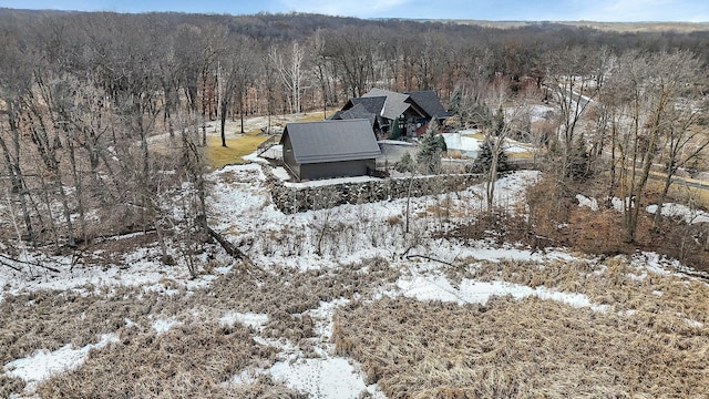 snowy aerial view featuring a forest view