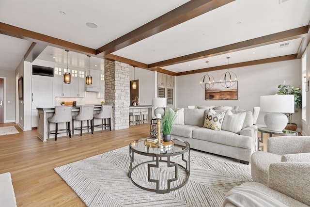 875 Lake St N Unit 402, Wayzata, MN 55391 - living area with light wood-type flooring, beamed ceiling, a chandelier, ornate columns, and baseboards