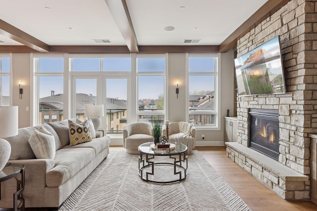 875 Lake St N Unit 402, Wayzata, MN 55391 - living area featuring light wood finished floors, a stone fireplace, visible vents, and beamed ceiling