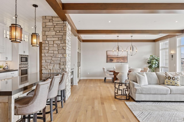 875 Lake St N Unit 402, Wayzata, MN 55391 - living area with light wood finished floors, beam ceiling, baseboards, and a notable chandelier