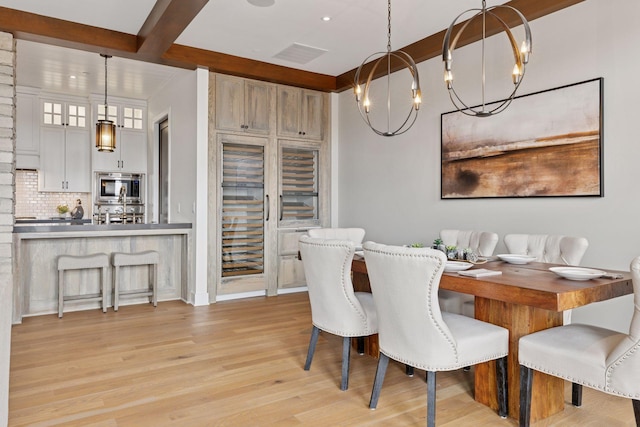 875 Lake St N Unit 402, Wayzata, MN 55391 - dining space with light wood-style flooring, beverage cooler, a chandelier, and recessed lighting