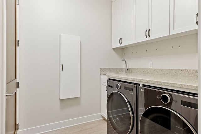 875 Lake St N Unit 402, Wayzata, MN 55391 - washroom featuring independent washer and dryer, cabinet space, baseboards, and light wood-type flooring