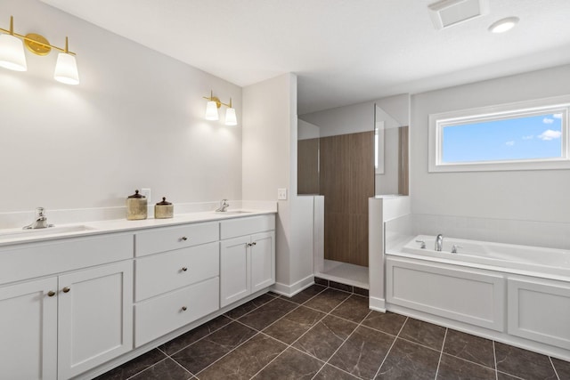 full bathroom featuring a garden tub, visible vents, walk in shower, and a sink