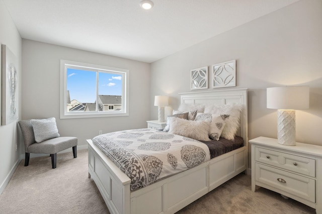 bedroom with light carpet and baseboards