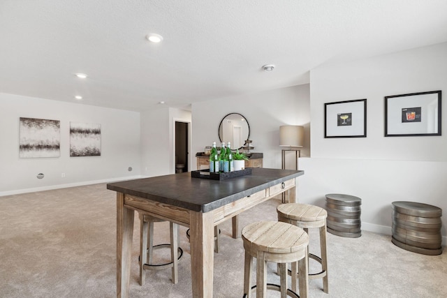 kitchen featuring light carpet, recessed lighting, and baseboards