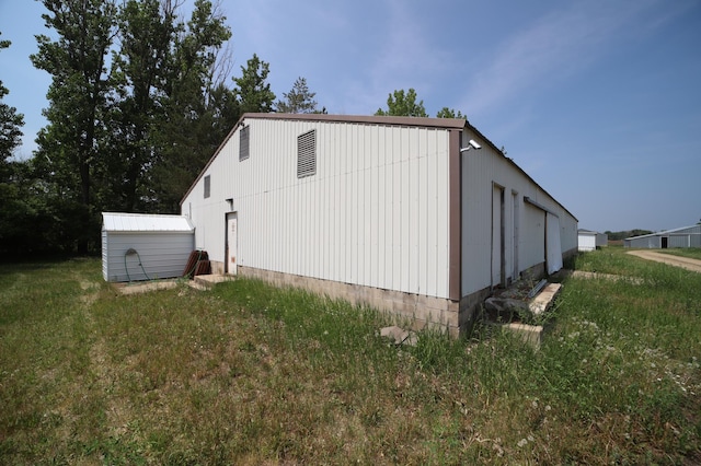 view of property exterior with an outbuilding, a yard, and a pole building