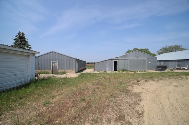 view of yard with a garage, a pole building, and an outdoor structure