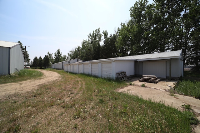 view of yard featuring a pole building, an outdoor structure, and community garages