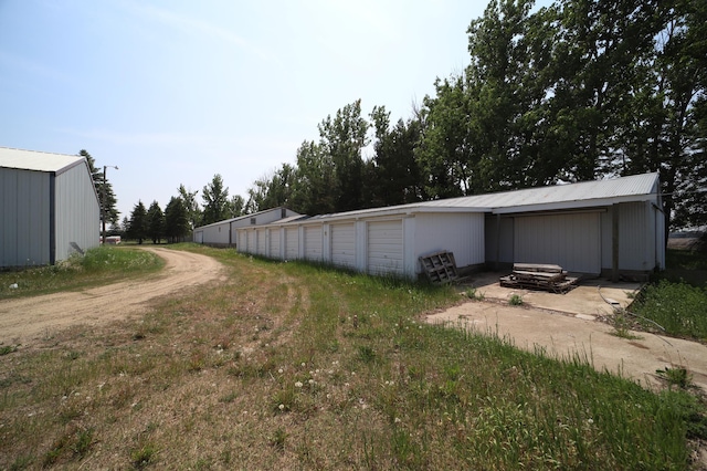 view of yard with an outbuilding and community garages