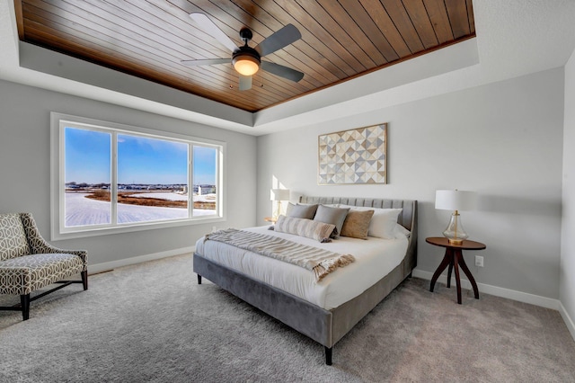 bedroom with wooden ceiling, a raised ceiling, carpet flooring, and baseboards