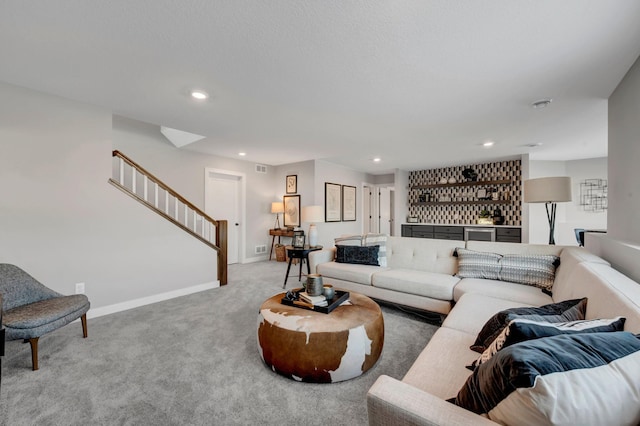 living room with stairs, indoor wet bar, light carpet, and recessed lighting