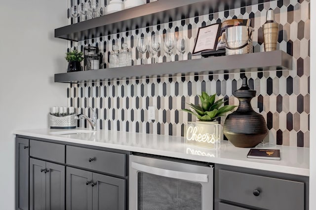 bar featuring beverage cooler and a sink