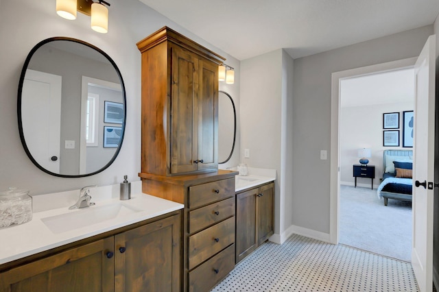 bathroom featuring double vanity, tile patterned floors, a sink, and baseboards