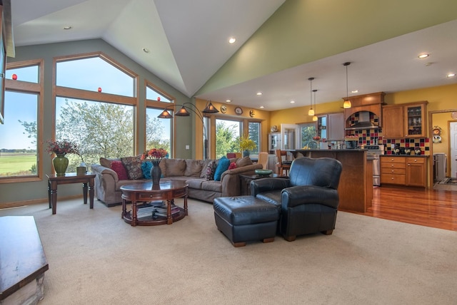 living area with high vaulted ceiling, recessed lighting, and carpet flooring