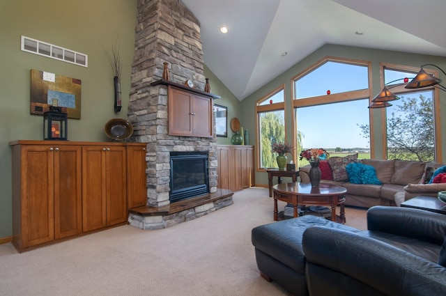 living area featuring light carpet, baseboards, visible vents, a stone fireplace, and high vaulted ceiling