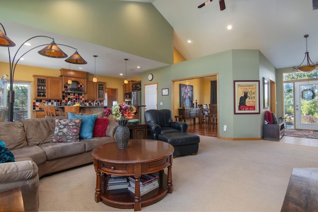 living room featuring high vaulted ceiling, recessed lighting, a healthy amount of sunlight, and light colored carpet