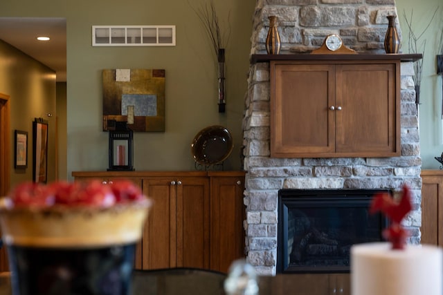 interior space featuring visible vents and a stone fireplace