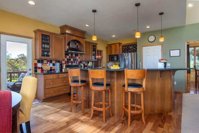 kitchen featuring stainless steel appliances, dark countertops, brown cabinets, and glass insert cabinets