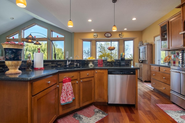 kitchen with stove, a sink, stainless steel dishwasher, brown cabinets, and dark wood-style floors