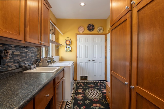 laundry room featuring separate washer and dryer, a sink, and cabinet space