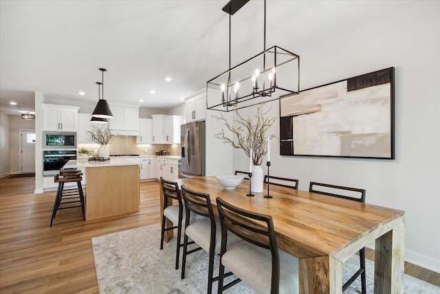 dining room with baseboards, light wood-type flooring, and recessed lighting