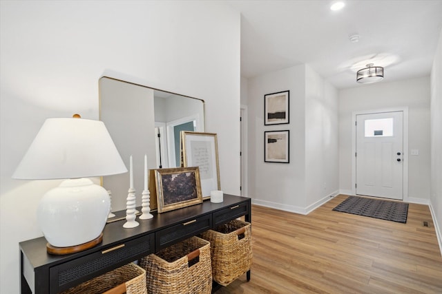 foyer featuring light wood-style floors and baseboards