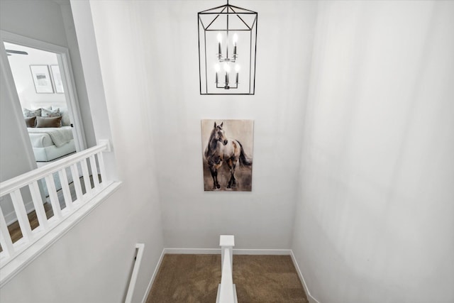 details featuring a notable chandelier, carpet floors, and baseboards