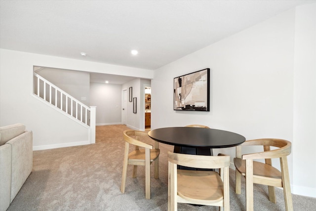 dining space featuring light carpet, stairs, baseboards, and recessed lighting