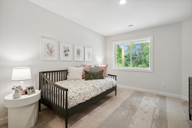 bedroom featuring baseboards and light colored carpet