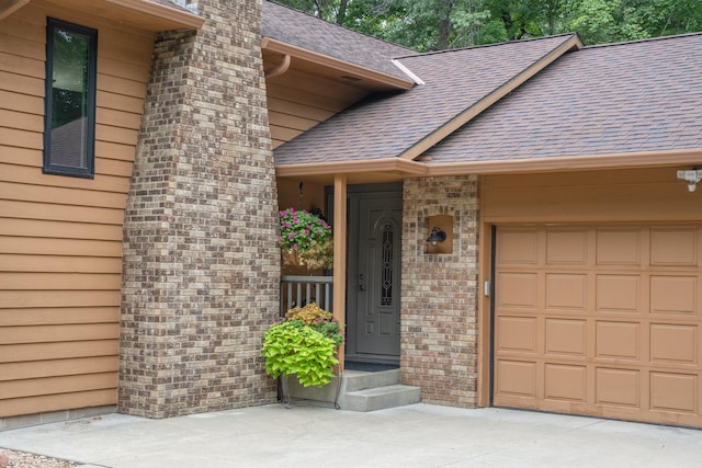 property entrance featuring a garage, a shingled roof, and a chimney