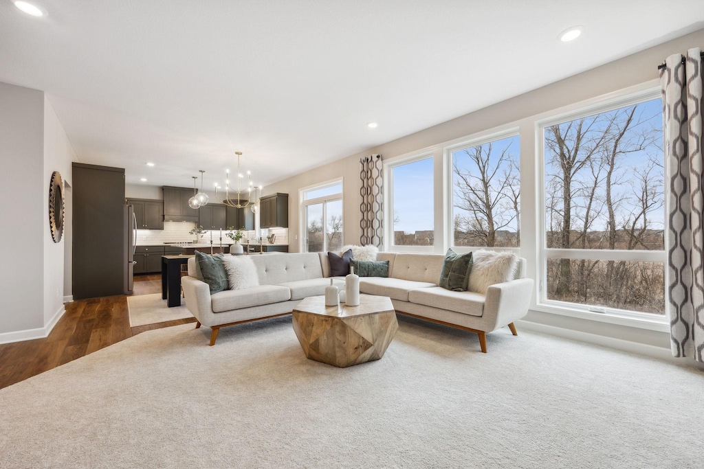 living room with recessed lighting, wood finished floors, baseboards, carpet, and an inviting chandelier