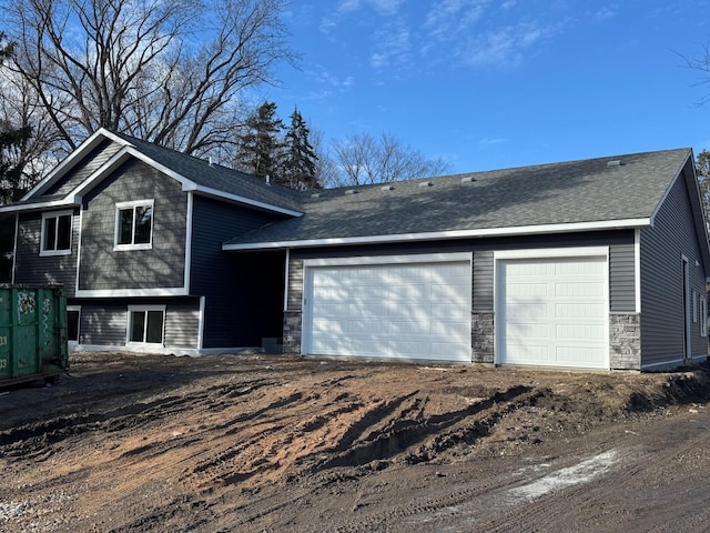 view of front of home with a garage and a shingled roof