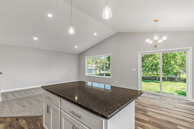 kitchen featuring open floor plan, dark wood-type flooring, decorative light fixtures, vaulted ceiling, and white cabinetry