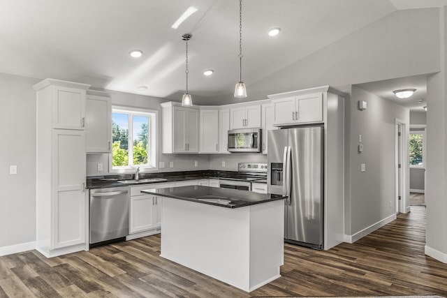 kitchen featuring stainless steel appliances, dark countertops, and white cabinetry