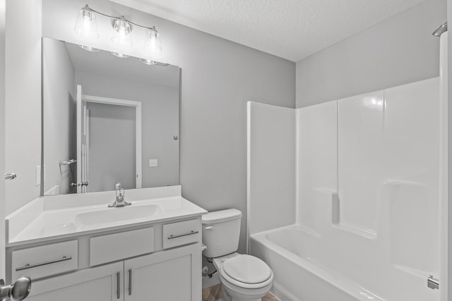 full bathroom with toilet, washtub / shower combination, a textured ceiling, and vanity