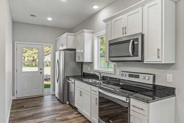 kitchen featuring appliances with stainless steel finishes, dark wood-type flooring, white cabinetry, a sink, and recessed lighting