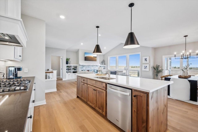 kitchen featuring open floor plan, appliances with stainless steel finishes, a wealth of natural light, and brown cabinets