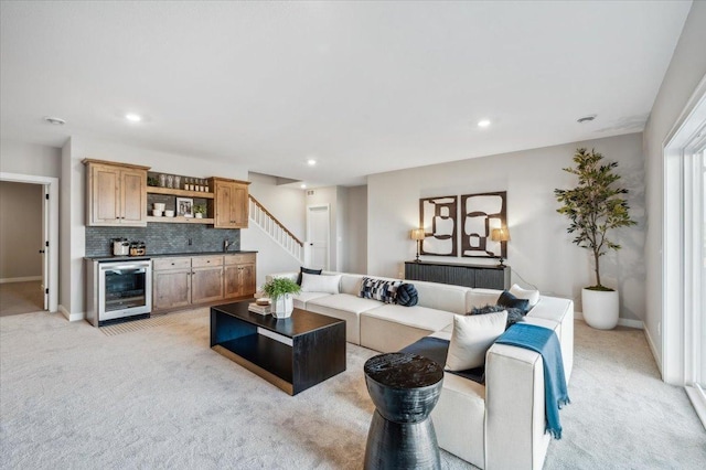 living room featuring wine cooler, a dry bar, recessed lighting, light colored carpet, and baseboards