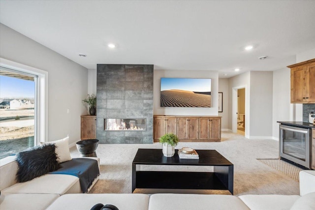 living room featuring recessed lighting, light colored carpet, a fireplace, and baseboards