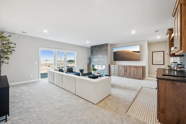 living room featuring baseboards, recessed lighting, and light colored carpet