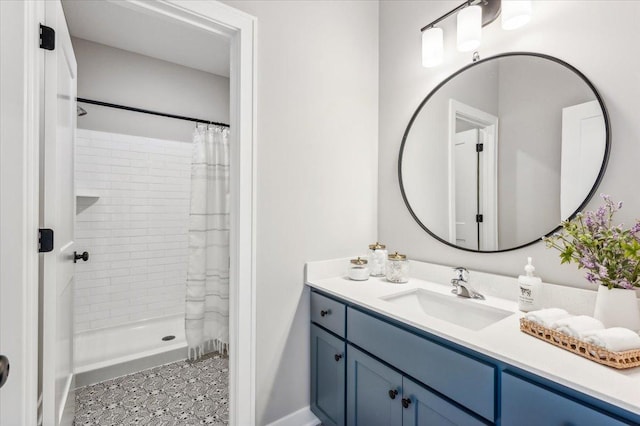 bathroom with tiled shower and vanity