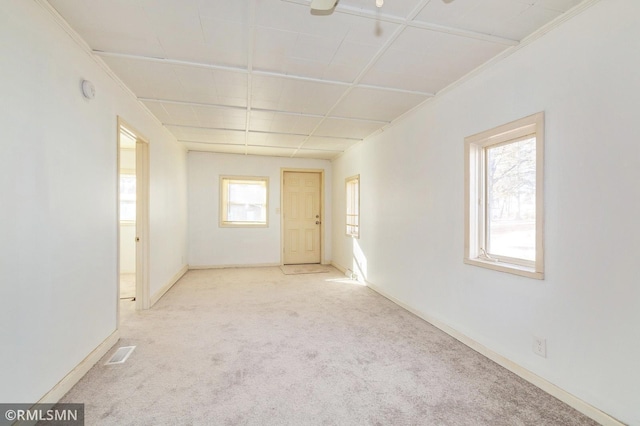 spare room featuring carpet floors, visible vents, and baseboards