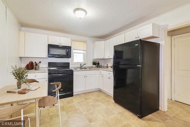 kitchen with a textured ceiling, a sink, white cabinets, light stone countertops, and black appliances