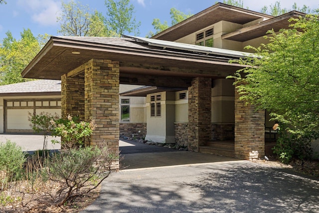 6 Black Lake Rd, North Oaks, MN 55127 - view of front of house featuring asphalt driveway, a garage, stone siding, and stucco siding