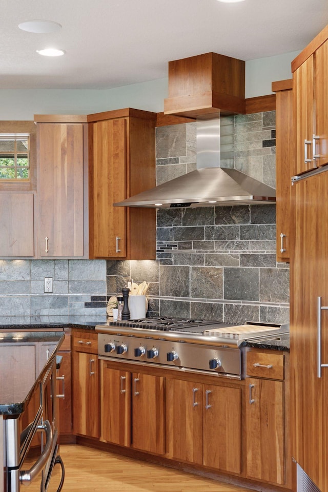 6 Black Lake Rd, North Oaks, MN 55127 - kitchen featuring wall chimney range hood, brown cabinetry, decorative backsplash, and dark stone counters