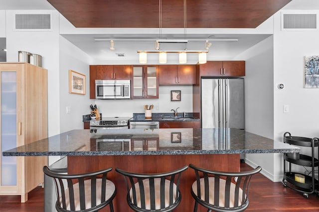 kitchen with a sink, visible vents, appliances with stainless steel finishes, and dark wood-style floors