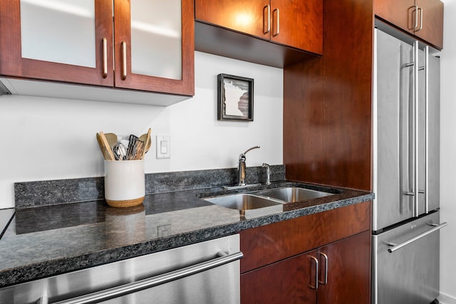 kitchen with a sink, stainless steel appliances, and glass insert cabinets