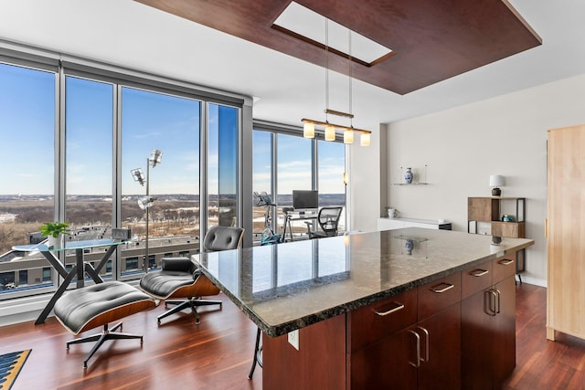 kitchen with expansive windows, a center island, dark stone counters, a skylight, and dark wood-style flooring