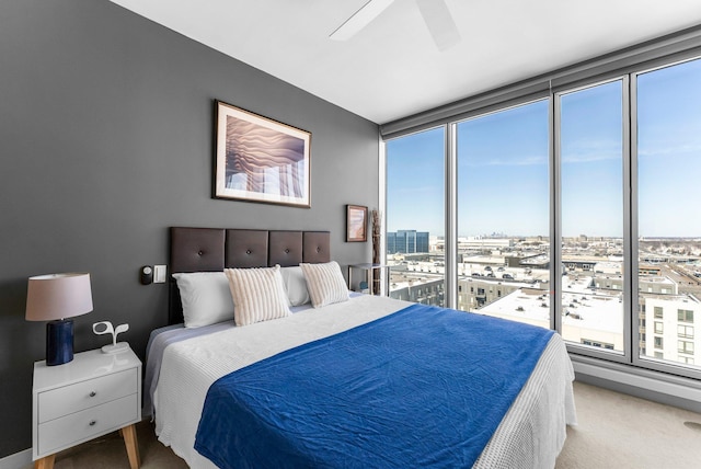 carpeted bedroom featuring a view of city and a ceiling fan